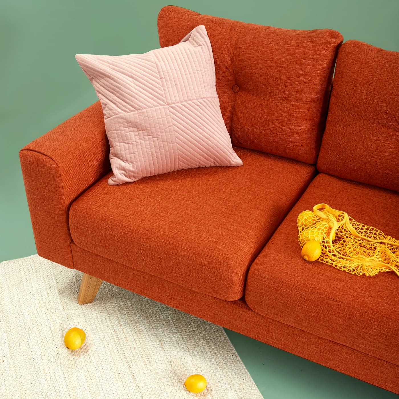 Terrakottafarbenes Sofa mit rosa Kissen